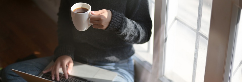 woman using laptop while holding a cup of coffee 3759083